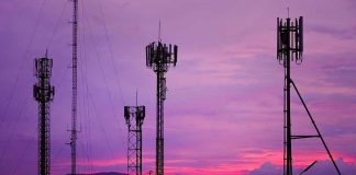 Cell towers against a purple sunset sky.