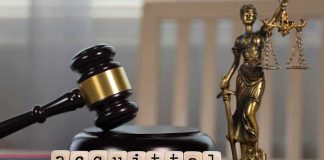 A gavel and the word acquittal spelled with letter blocks on a desk