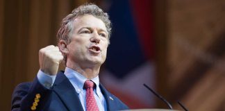 Man in a suit passionately delivering a speech at a podium