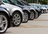 A row of parked black and silver cars in a dealership