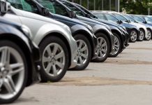 USED Cars Sold as NEW — Incredible FRAUD Exposed A row of parked black and silver cars in a dealership