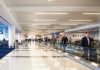People walking through a busy airport terminal.