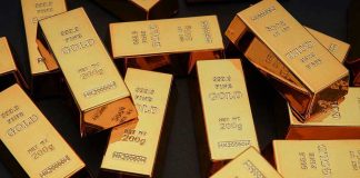 Gold bars stacked on dark background