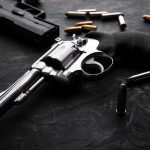 Christmas Carolers TERRORIZED by Armed Homeowner Revolvers and bullets on a dark surface.