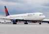 SHOCKING Airline Cover-Up Leaves Passengers Bleeding Delta Airlines airplane on airport runway, cloudy sky.