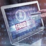 Minnesota Fraud Scandal Sparks Terrorism Fears Person holding credit card near laptop displaying Fraud.