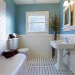 Modern bathroom with blue walls and white fixtures.