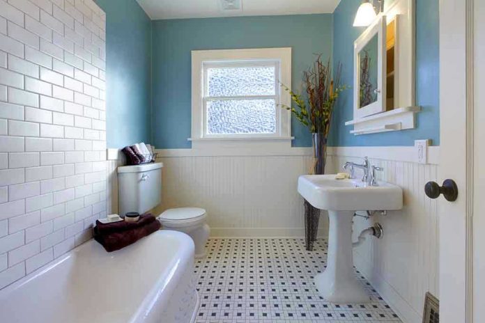 Modern bathroom with blue walls and white fixtures.