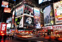 Vibrant night scene of Times Square filled with theater advertisements and neon lights