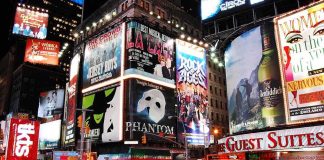 Vibrant night scene of Times Square filled with theater advertisements and neon lights