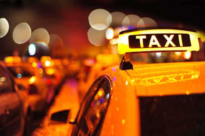 shutterstock_113840083.jpg Close-up of a taxi sign illuminated at night with blurred city lights in the background
