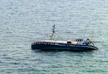 An abandoned boat floating on the ocean surface
