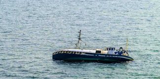An abandoned boat floating on the ocean surface
