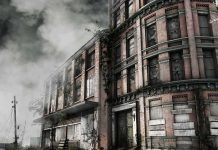 Abandoned building with overgrown plants and construction cones in the foreground