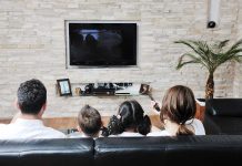 A family of four watching television together in a cozy living room