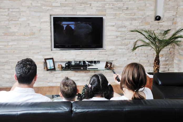 A family of four watching television together in a cozy living room