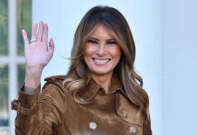 Melania DEMOLISHES Traditional First Lady Playbook Completely Person smiling and waving wearing a brown coat