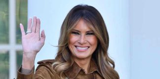 Melania DEMOLISHES Traditional First Lady Playbook Completely Person smiling and waving wearing a brown coat