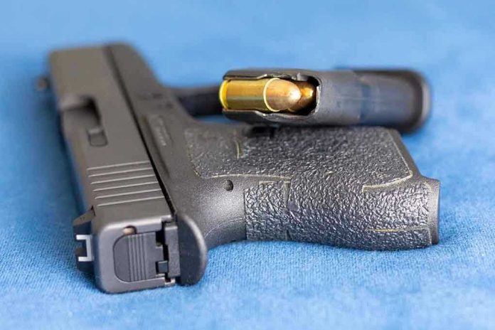 Handgun on blue fabric with visible bullet cartridge.