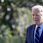 Biden Healthcare SCANDAL — $27 Billion Theft EXPOSED Man in a suit standing outdoors, blurry background.