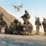 US-China Tensions Drive AI-Military Alliance Soldiers operating a drone in a desert environment.