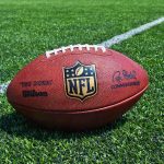 Gunmen TARGET Football Fans During Historic Game An NFL football resting on a green grass field