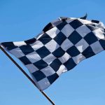 Trump’s IndyCar Surprise—Racing Through National Mall A checkered flag waving against a clear blue sky
