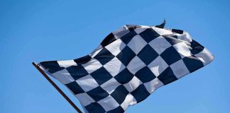 Trump’s IndyCar Surprise—Racing Through National Mall A checkered flag waving against a clear blue sky