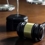 Judge Slashes Rapist’s Sentence in Half Gavel and scales of justice on wooden table.