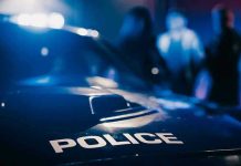 WNBA Star ARRESTED After Title Night Police car with blurred figures in the background.