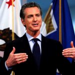 California’s Bold Move: Tax ALL Trump Payouts Man speaking with flags in the background