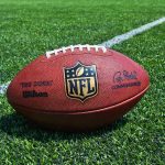 NFL Star’s Trump Intro Sparks Media Uproar NFL football on a green field.