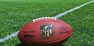 NFL Star’s Trump Intro Sparks Media Uproar NFL football on a green field.