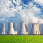 Hidden AI Tax Drains Wallets And Water Nuclear power plant with cooling towers emitting steam against a blue sky