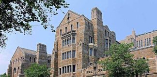 Graduates UNLEASH on AI—Major Commencement Drama! Historic university building with stone facade and surrounding trees