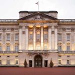 Prince Andrew’s Shocking Fraud Investigation Unfolds Front view of Buckingham Palace with illuminated facade and British flag