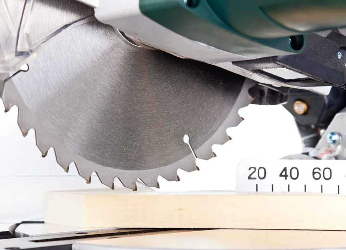 Close-up of a circular saw blade cutting through a piece of wood