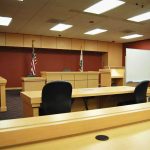 Justice Resigns Over Alleged Affair Scandal Interior view of an empty courtroom with wooden furniture and American flags