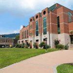 Shock Announcement: Graduation Speaker Wipes Student Debt! Modern educational building on a college campus with landscaped grounds
