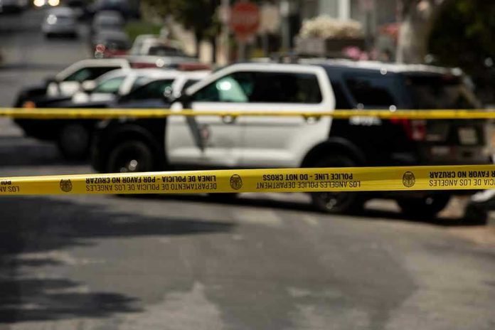 Police tape blocking street with patrol cars.