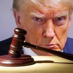 Gavel in front of a serious mans face.