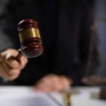 BIDEN Judge HOBBLES ICE Nationwide! Hand holding gavel in courtroom setting.