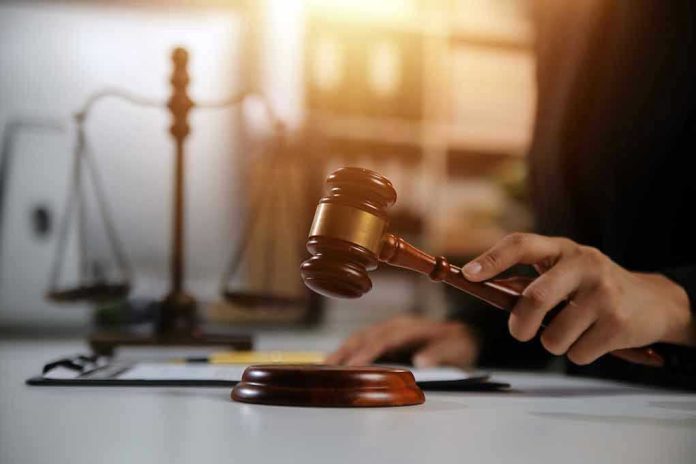2478909667-1 Gavel being struck near scales of justice.