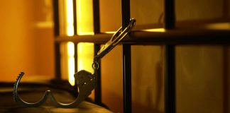 PAROLE DISASTER — Third Victim After Two Releases Open handcuffs hanging in dimly lit cell