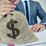 Person holding burlap bag with dollar sign.