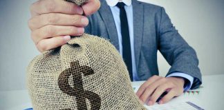 Person holding burlap bag with dollar sign.