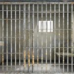 Empty rusty prison cell with a small window.