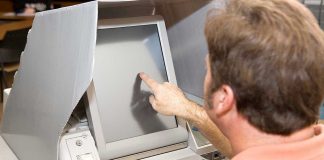 Trump BACKED Latin American ALLY Stuns The LEFT Person using touchscreen voting machine in polling booth.