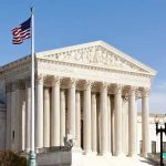 United States Supreme Court building with American flag.