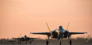 Jets on runway at sunset.